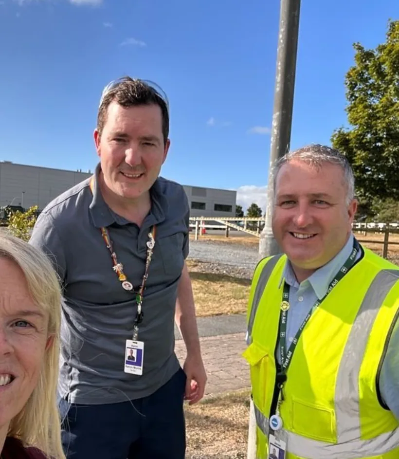 Three Amgen colleagues taking a selfie on a walk around the site